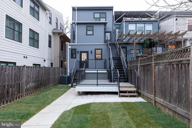 a view of backyard with wooden fence and a large tree