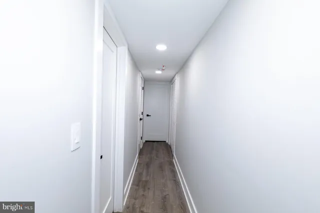 a view of a hallway with wooden floor