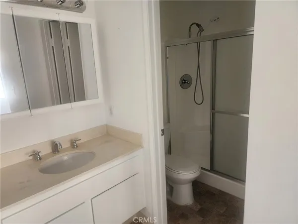 a bathroom with a granite countertop sink toilet and shower