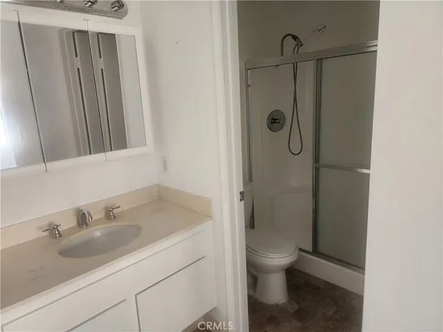 a bathroom with a granite countertop sink toilet and shower