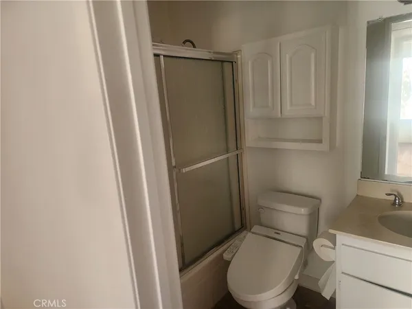 a white toilet sitting next to a shower