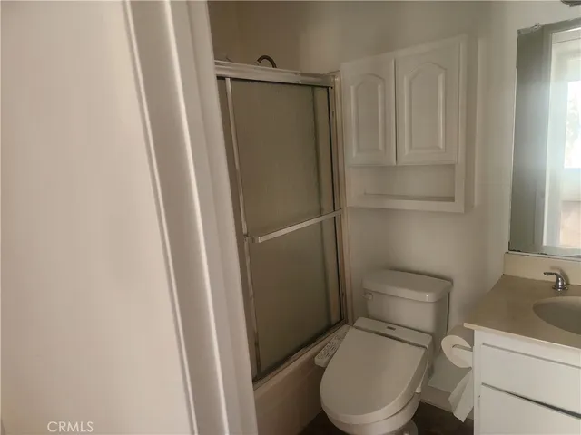 a white toilet sitting next to a shower