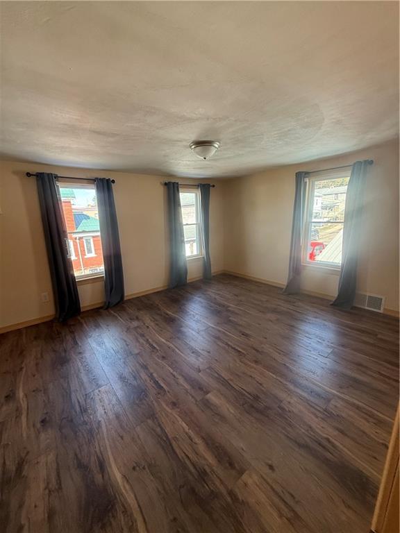 302 Neubert Street Kittanning, PA 16201 - Photo 9 of 23 an empty room with wooden floor and windows