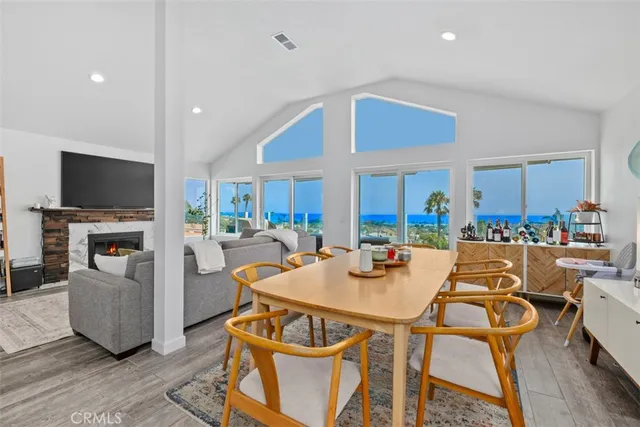 a view of a dining room with furniture a fireplace and wooden floor