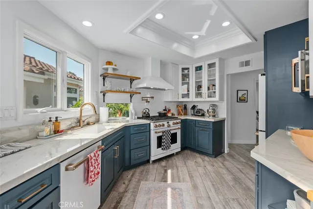 a large kitchen with stainless steel appliances granite countertop a lot of counter space and wooden floors