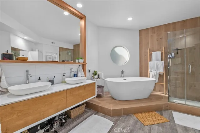 a bathroom with a double vanity sink mirror and bathtub