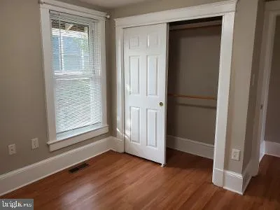 a view of a small space with wooden floor and a window