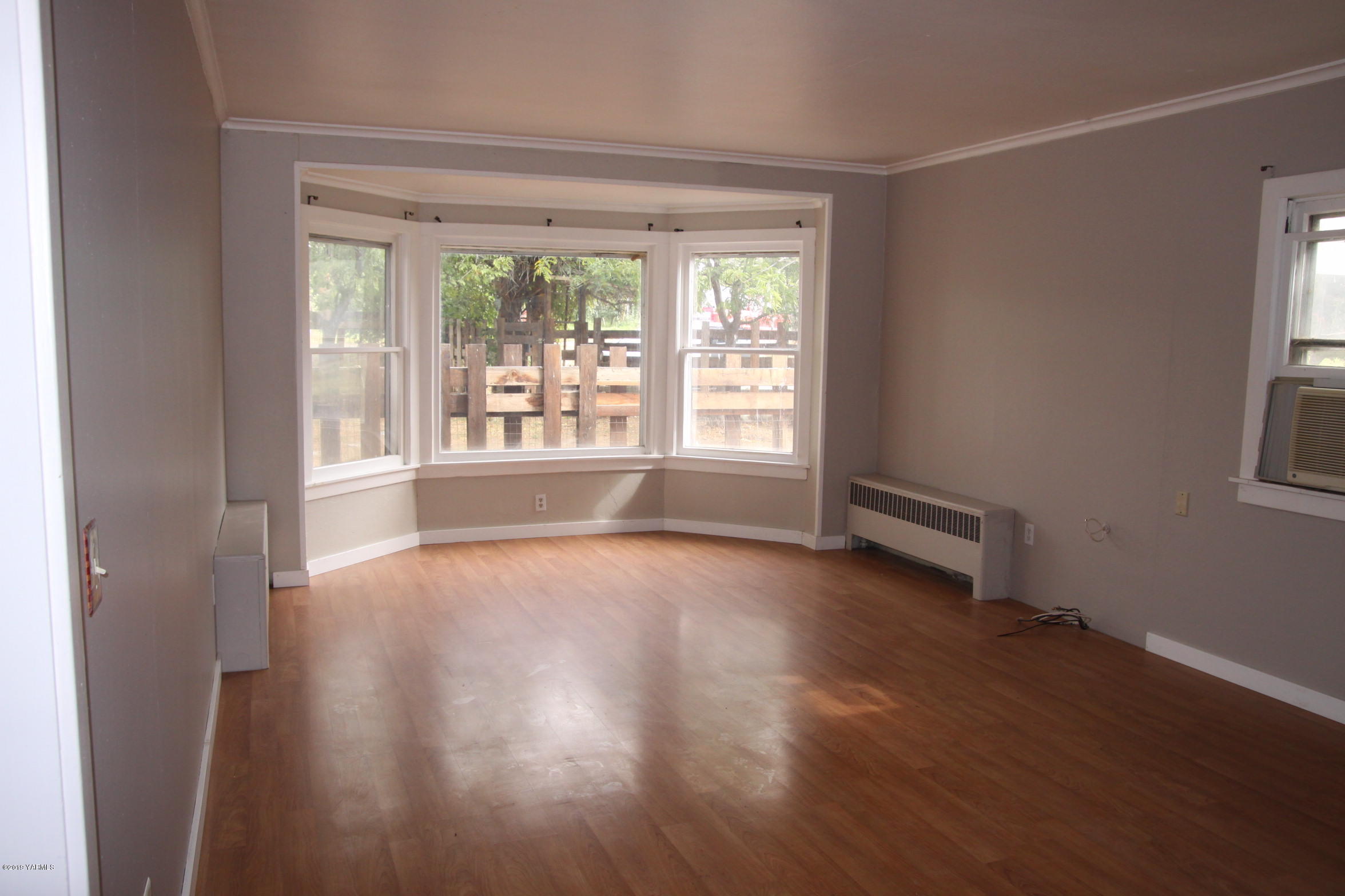 741 McPhee Road Naches, WA 98937 - Photo 2 of 16 a view of an empty room with wooden floor and a window
