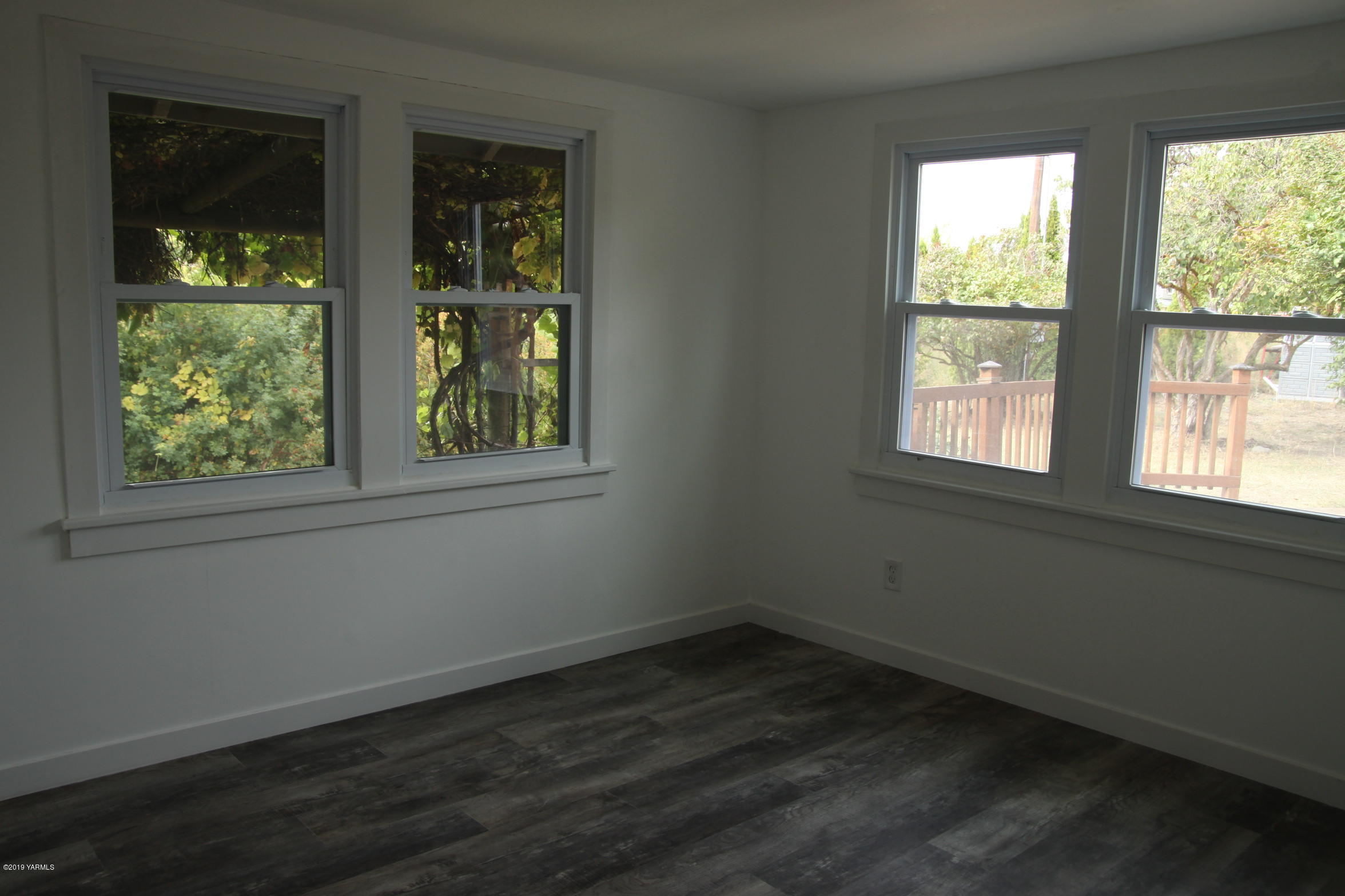 741 McPhee Road Naches, WA 98937 - Photo 8 of 16 an empty room with wooden floor and windows