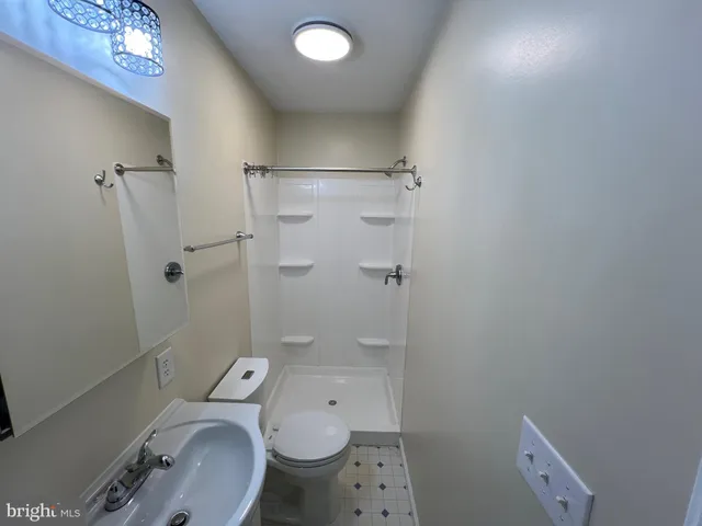 a bathroom with a granite countertop toilet a sink and shower