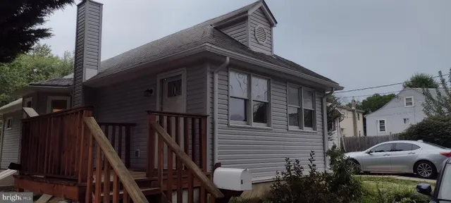 a view of a house with a car parked side of road