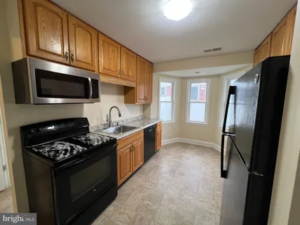 a kitchen with stainless steel appliances granite countertop a stove refrigerator and microwave