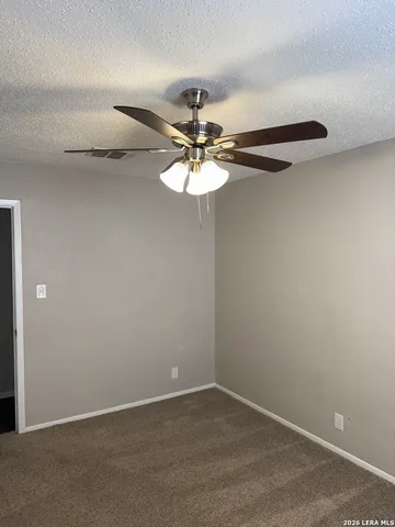 a view of a room with a chandelier fan