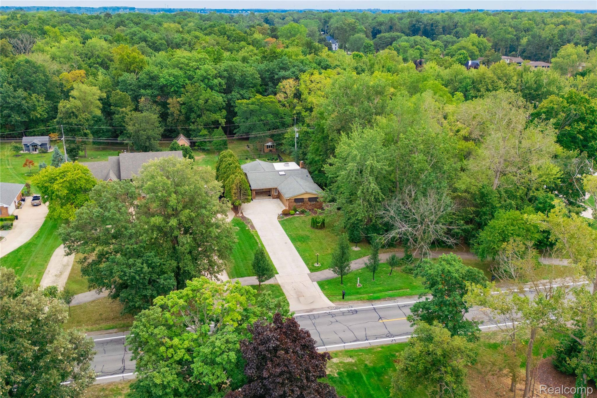 25645 Meridian Road Grosse Ile, MI 48138 - Photo 33 of 46 Expansive property with a long paved driveway, surrounded by mature trees and lush green landscaping