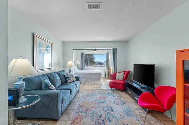 a bedroom with a large bed and a chandelier