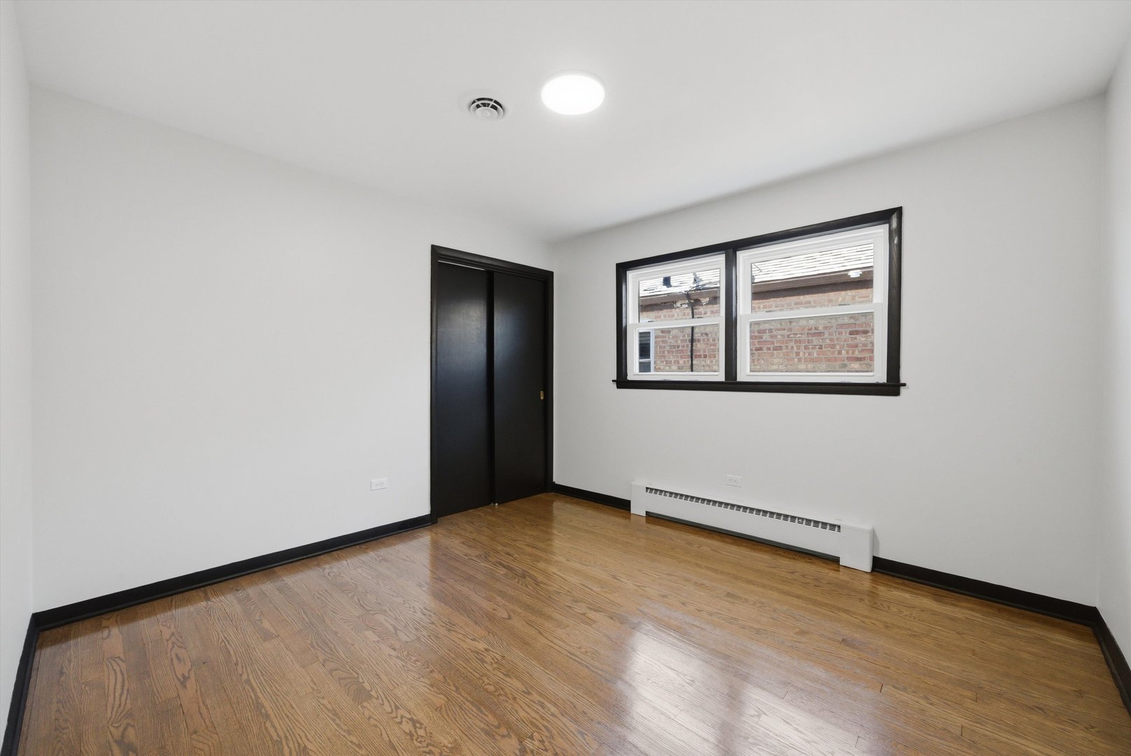 3907 West Marquette Road Chicago, IL 60629 - Photo 5 of 32 an empty room with wooden floor and windows