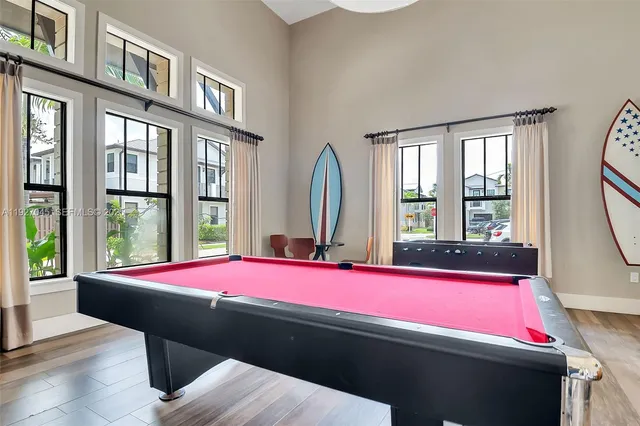 a room with pool table and windows