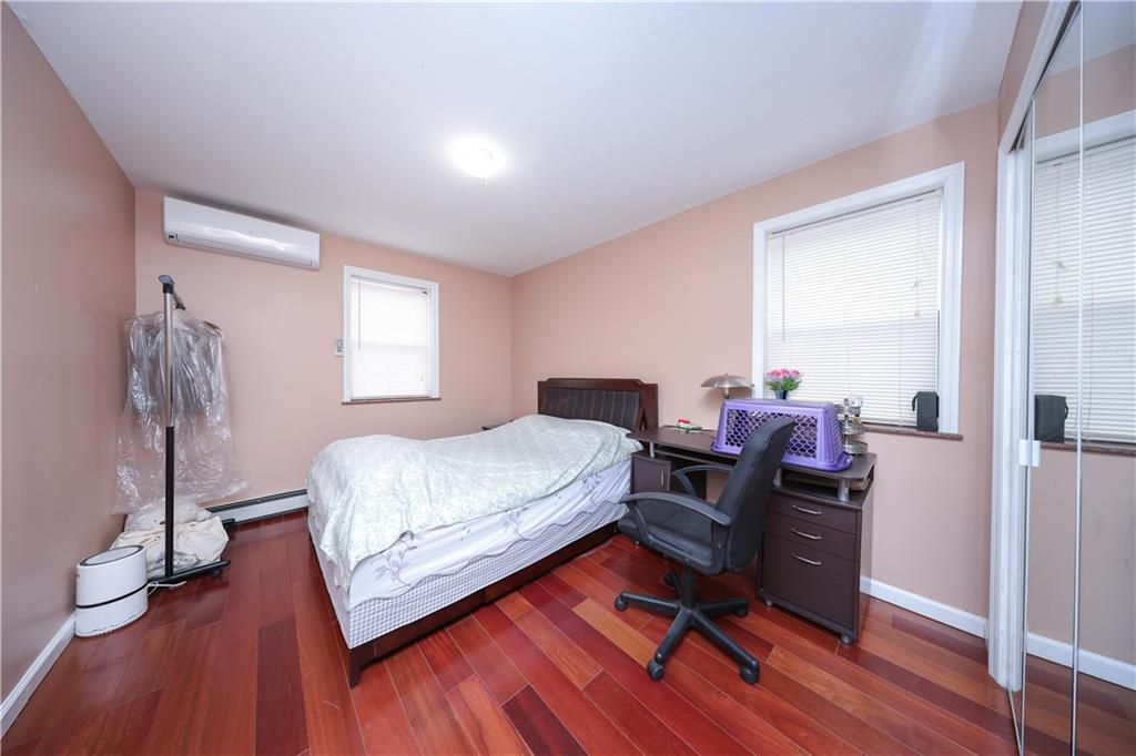 8756 26th Avenue Brooklyn, NY 11214 - Photo 13 of 26 a bedroom with a bed and wooden floor
