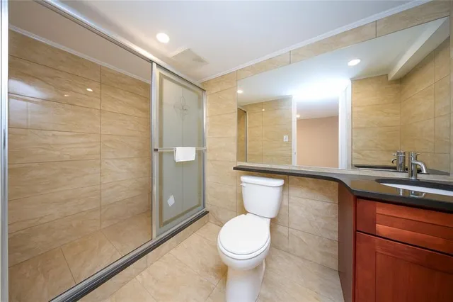 a bathroom with a toilet a sink and glass door