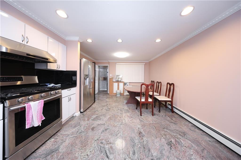 8756 26th Avenue Brooklyn, NY 11214 - Photo 8 of 26 a living room with stainless steel appliances furniture a fireplace and a open kitchen view