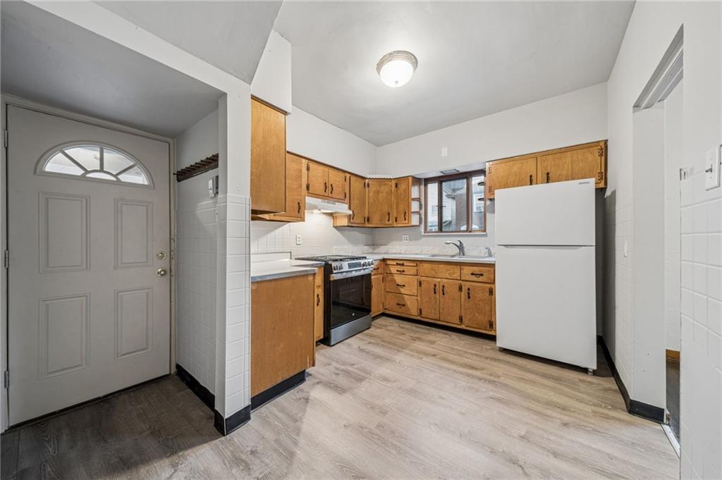 620 Broadway Avenue McKees Rocks, PA 15136 - Photo 2 of 18 a kitchen with refrigerator a sink and a stove top oven