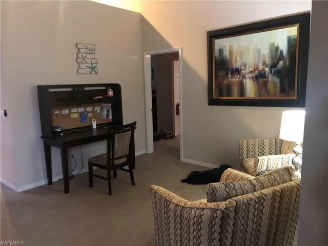 a living room with furniture and a painting on the wall