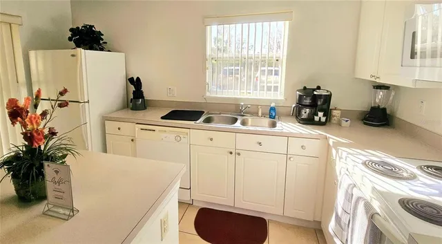 a kitchen with a sink a stove and white cabinets