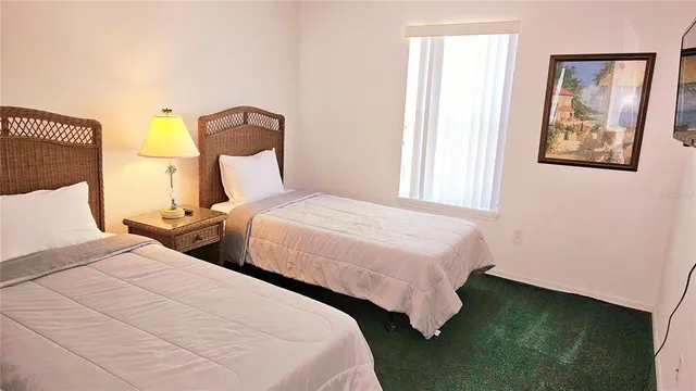 a bedroom with two beds and painting on the wall