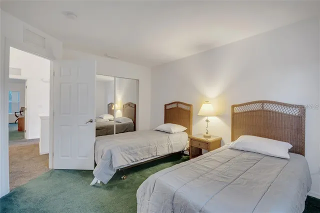 a bedroom with two bed and a lamp