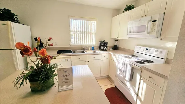 a kitchen with a white stove top oven and sink