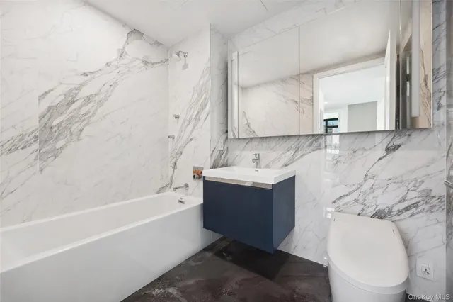 a bathroom with a bathtub sink vanity and toilet