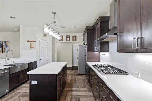 a kitchen with stainless steel appliances a stove sink and refrigerator
