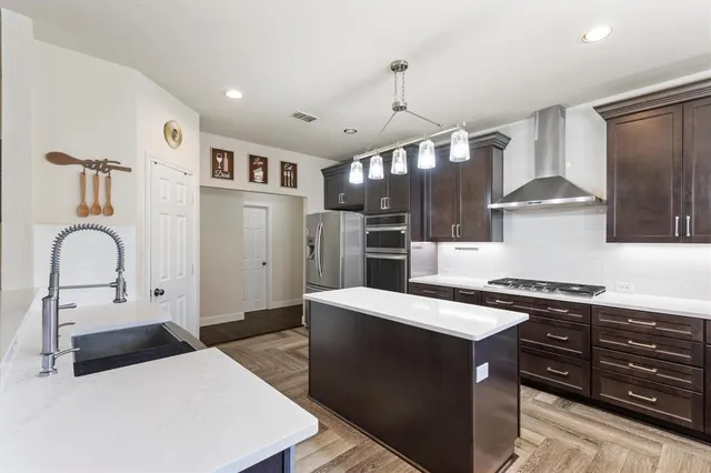 a kitchen with stainless steel appliances granite countertop a sink a stove and a refrigerator