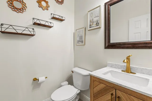 a bathroom with a sink mirror vanity and toilet