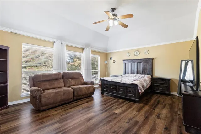 a bedroom with a bed a couch and a chandelier