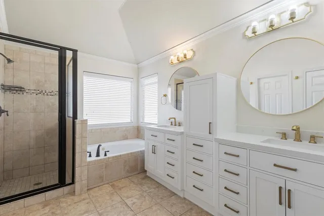 a bathroom with a double vanity sink mirror and bathtub