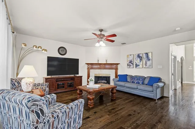 a living room with furniture a flat screen tv and a fireplace