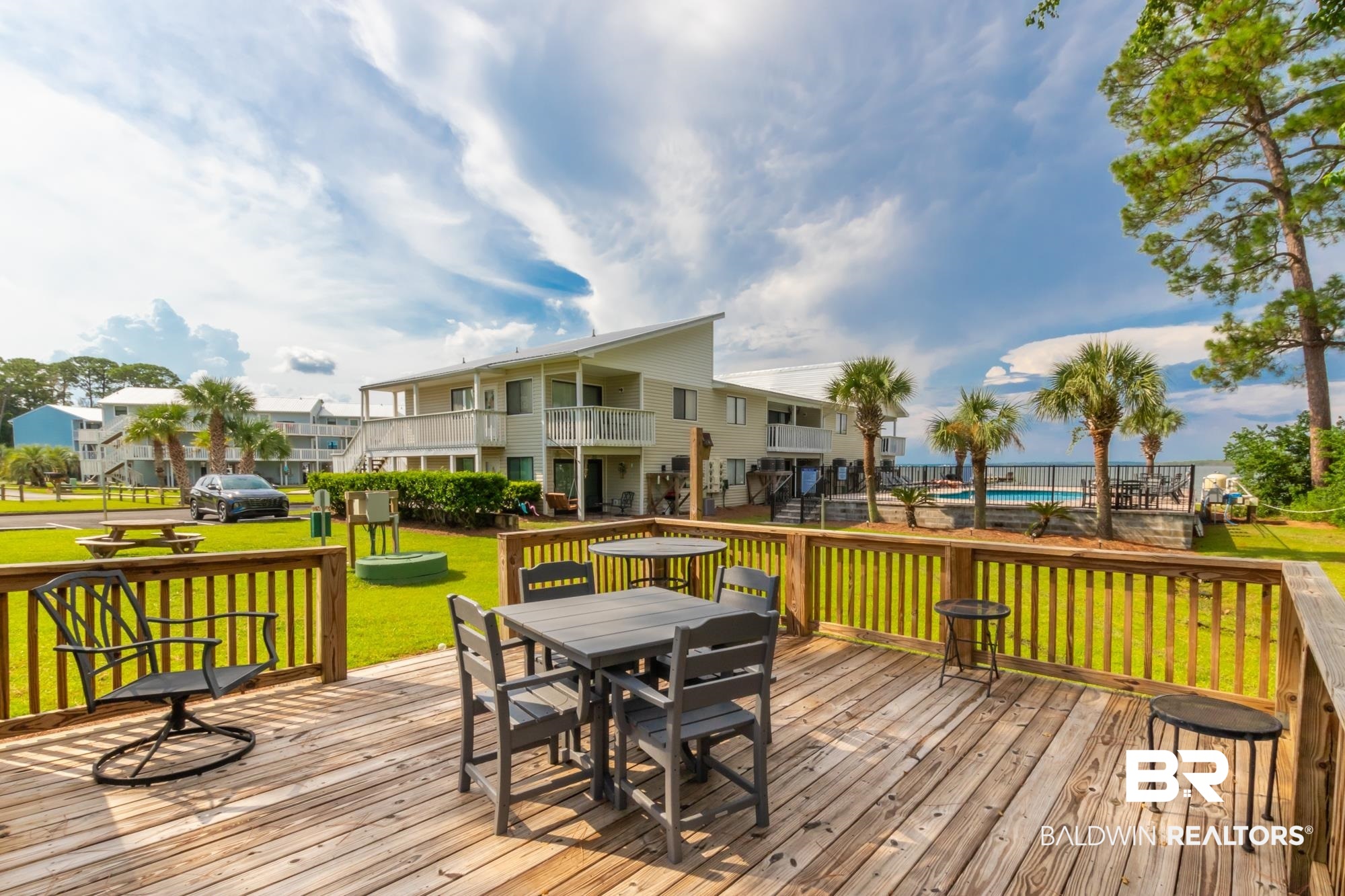 25925 -C Canal Road, Unit 203 Orange Beach, AL 36561 - Photo 40 of 57 Wooden deck with a lawn and a pool