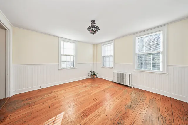wooden floor in an empty room with a window