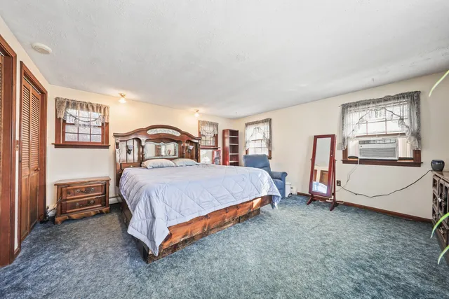 a spacious bedroom with a bed and a flat tv screen