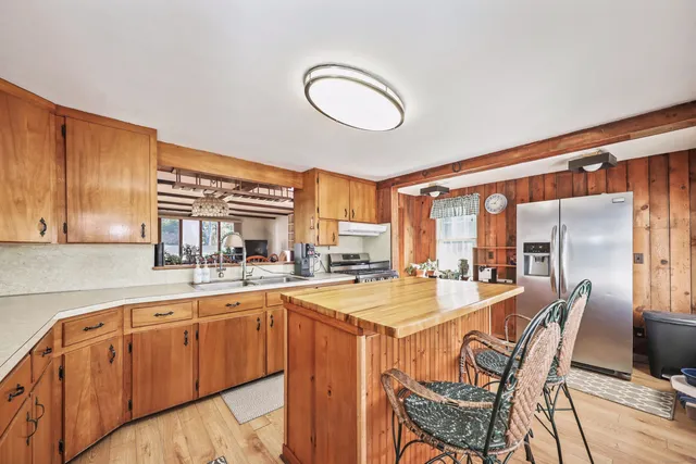 a dining hall with stainless steel appliances granite countertop a sink and cabinets