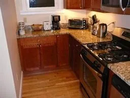 a kitchen with granite countertop a sink stove and cabinets