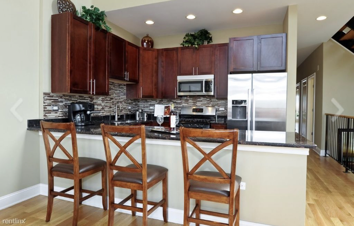 27 North Morgan Street, Unit 3 Chicago, IL 60607 - Photo 2 of 6 a kitchen with stainless steel appliances a refrigerator a stove a sink and a chairs with wooden floor