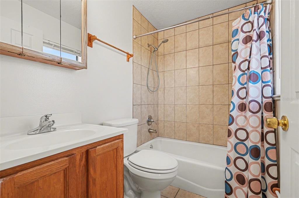 816 Angela Avenue, Unit B Rockledge, FL 32955 - Photo 9 of 34 a bathroom with a sink a toilet and shower curtain