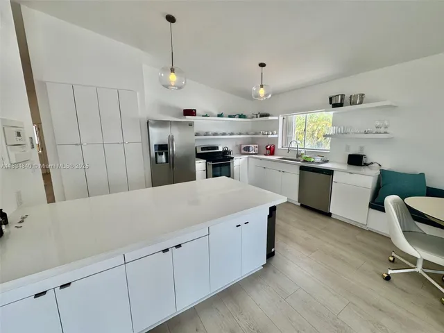 a kitchen with cabinets a sink and appliances