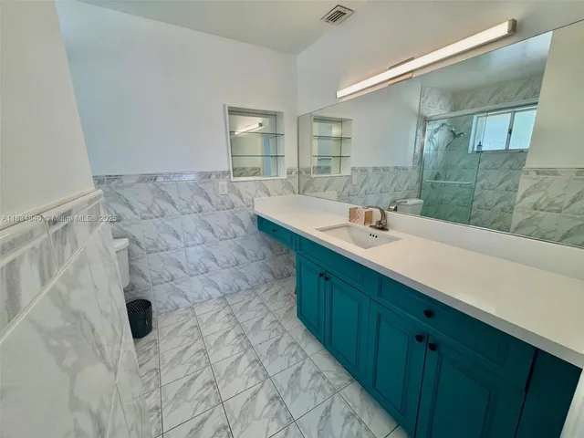 a bathroom with a sink mirror and shower