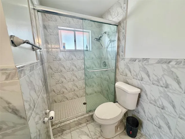 a white toilet sitting next to a bathroom sink