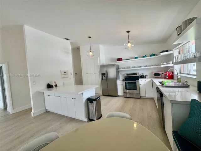 a open kitchen with cabinets a stove and wooden floors