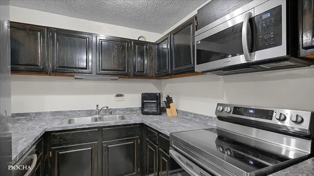 a kitchen with granite countertop a stove and a sink