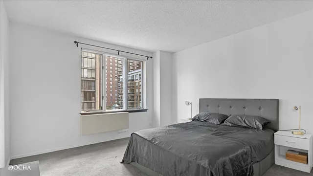 a bedroom with a bed a table and a window